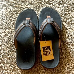 Black with brown trim Reef Flip Flops size 8. Never worn. Purchased 6 months ago